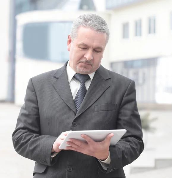 Affärsman med digital tablett står nära kontorsbyggnad — Stockfoto