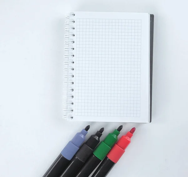 Marcadores multicolores y bloc de notas abierto aislado en el fondo blanco —  Fotos de Stock