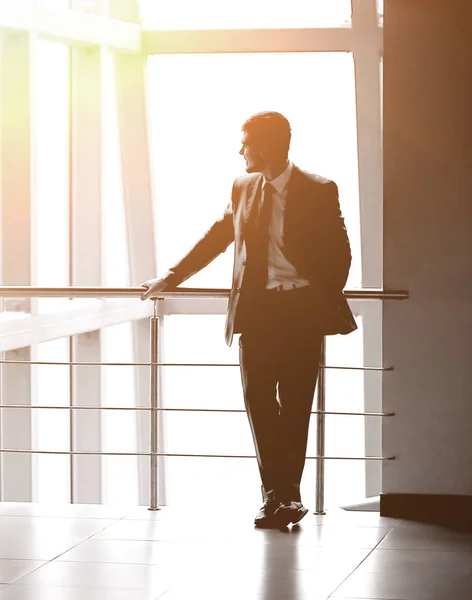 Framgångsrik affärsman står i lobbyn på ett modernt kontor — Stockfoto