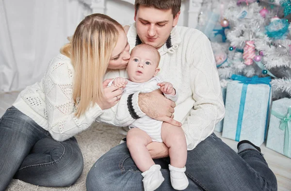 Padres felices besan a su bebé en la víspera de Navidad — Foto de Stock