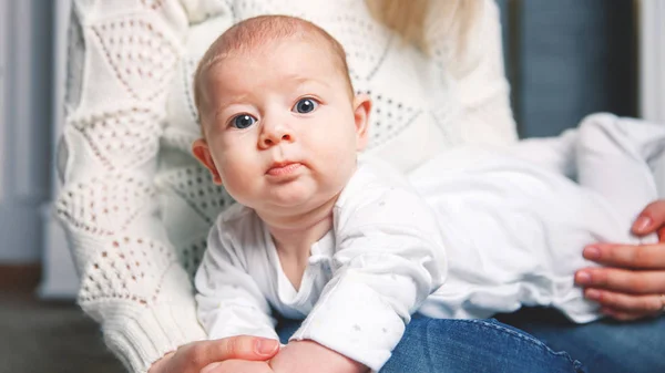 Niño pequeño en las manos de las madres. emociones humanas positivas, mira en el marco — Foto de Stock