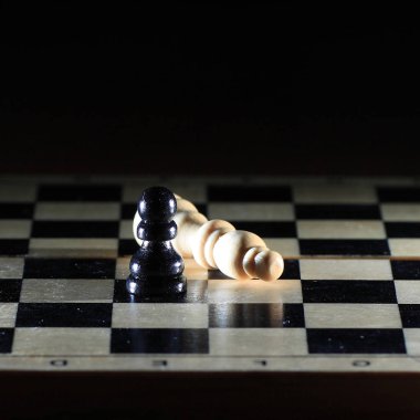 Karanlık bir arka plan üzerinde parlak satranç tahtası üzerinde satranç figürleri ile kompozisyon