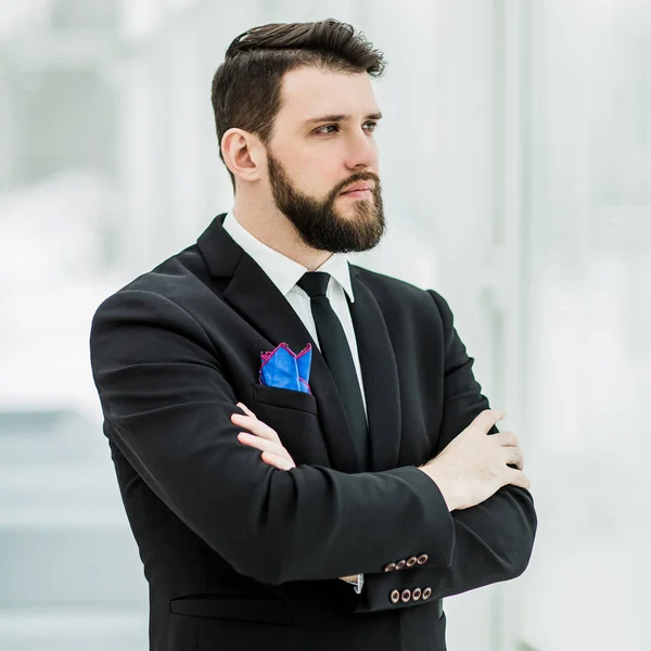 Exitoso hombre de negocios de pie cerca de una ventana en la oficina brillante . — Foto de Stock