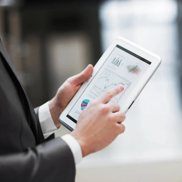 Business person analyzing financial statistics displayed of the tablet screen — Stock Photo, Image