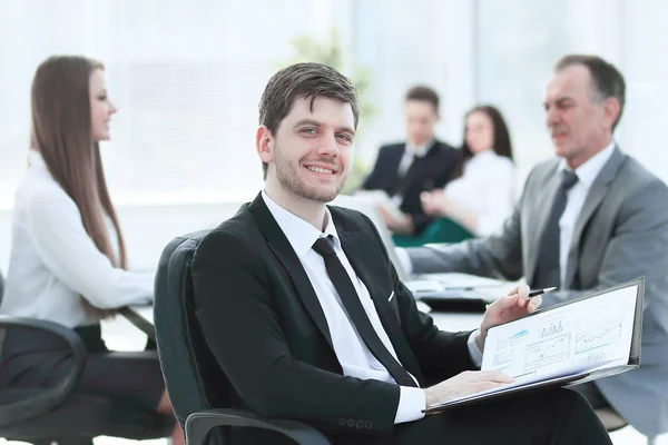 Hombre de negocios en la oficina con su equipo de negocios trabajando detrás —  Fotos de Stock