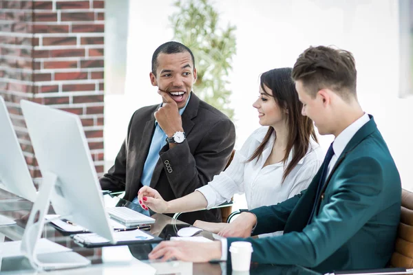 Equipo profesional de negocios hablando mientras está sentado detrás de un escritorio —  Fotos de Stock