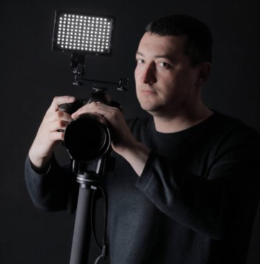 tripod.isolated siyah arka plan üzerine kamera ile profesyonel fotoğrafçı