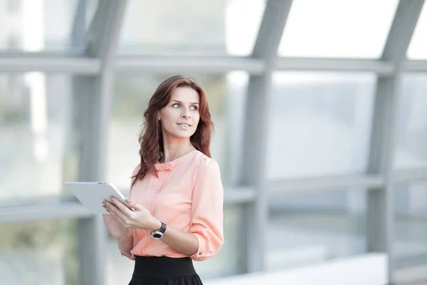 Confident business woman with digital tablet on blurred office background. — Stock Photo, Image