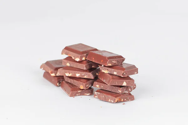 Kawałki gorzkiej czekolady z orzechami na białym tle na white.photo z — Zdjęcie stockowe