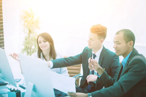 Equipo de negocios hablando mientras está sentado en un escritorio — Foto de Stock