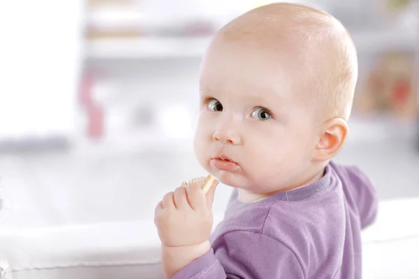 Close-up. mooie baby eet cookies en kijkt naar de camera — Stockfoto