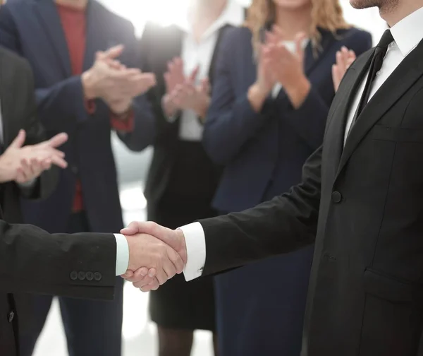 Vicino. stretta di mano di partner commerciali sullo sfondo di applaudire business team — Foto Stock