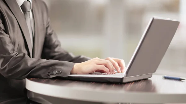 Close up.businessman escribir en un ordenador portátil, sentado en una pestaña de café — Foto de Stock