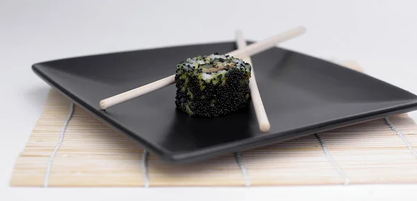 寿司和筷子在黑盘上的特写 — 图库照片
