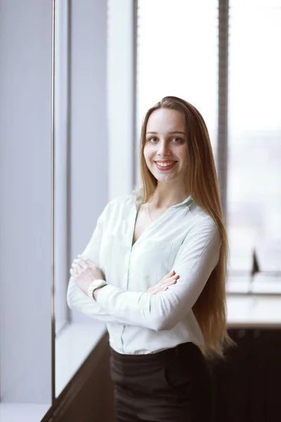 Business woman standing near the window in the corridor of the office. — Stock Photo, Image