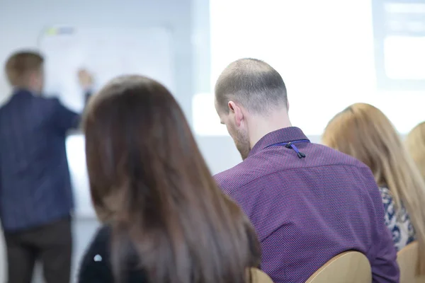 rear view.business team listening to the speaker