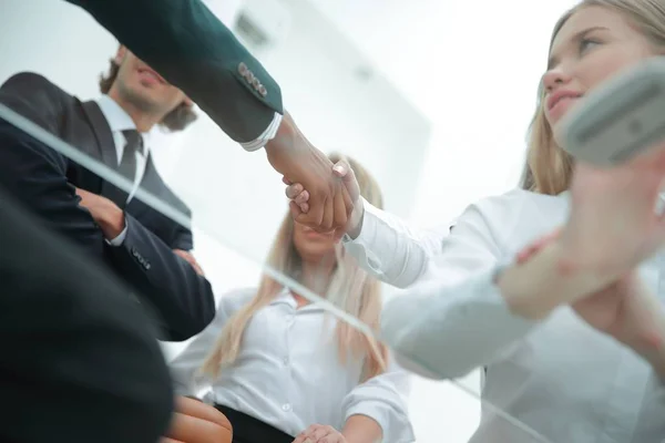Vista inferior .handshake mujeres de negocios con un socio de negocios — Foto de Stock