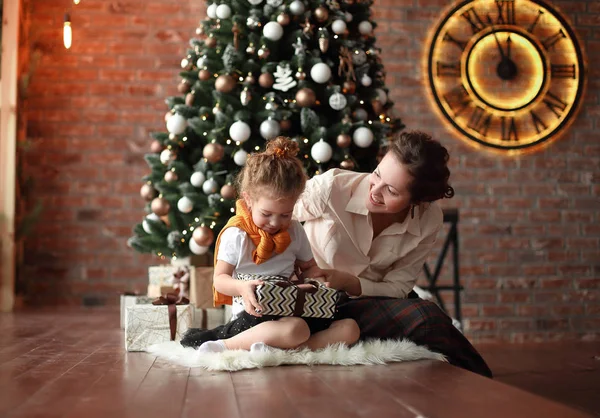 Noel ağacının yanında oturan küçük kızı anne konuştuğu — Stok fotoğraf