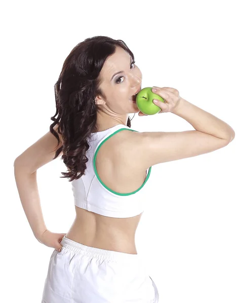 Fitness woman giving you an green apple and smiling on white isolated — Stock Photo, Image