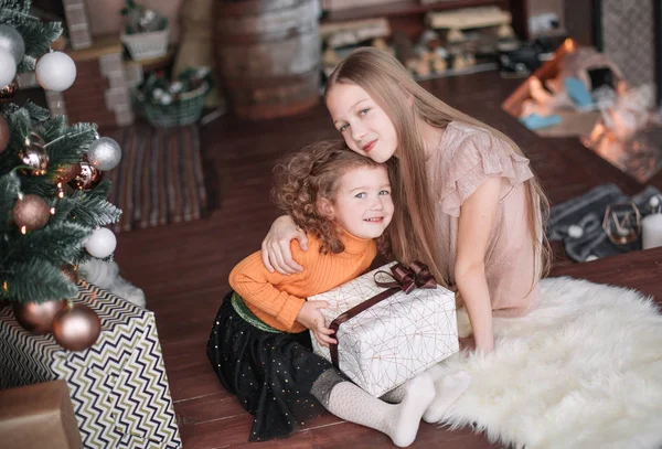 Noel arifesinde katta oturan iki güzel kız kardeş — Stok fotoğraf