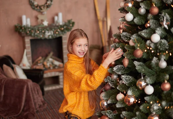 Uśmiechnięta dziewczyna dekorowanie choinki w jej salonie — Zdjęcie stockowe