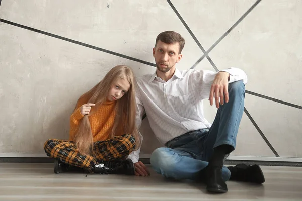 Vater und kleine Tochter sitzen zusammen an der Wand — Stockfoto