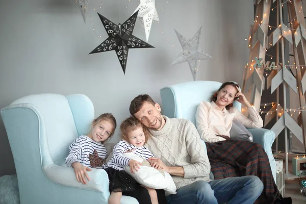 Feliz familia sentada en la sala de estar noche de Navidad . — Foto de Stock