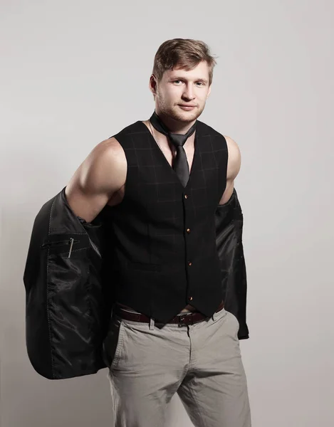 Bir gömlek olmadan iş takım elbiseli genç işadamı bir ceket omzunun üstünde tutar. — Stok fotoğraf