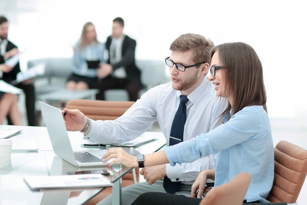 Young business man working together with her colleague on laptop in office.
