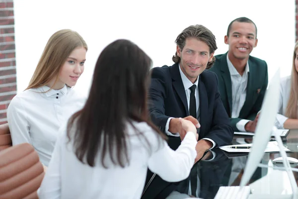 Apretón de manos a las mujeres de negocios con su socio en la mesa de negociaciones —  Fotos de Stock