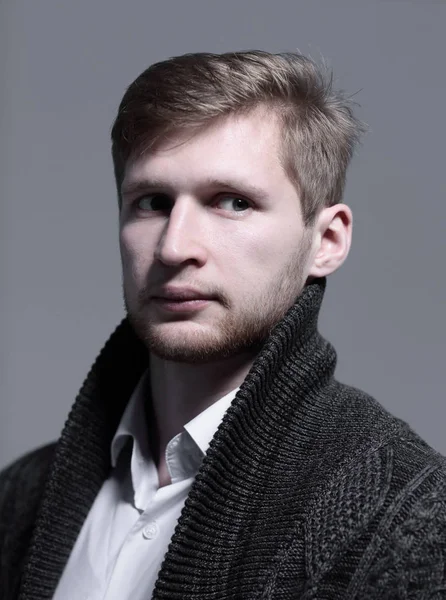 Close up.a stylish young man in a cardigan.isolated on grey background — Stock Photo, Image