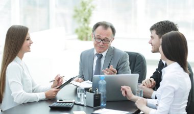 Müdürü ile yardımcıları masa başında iş sorunları tartışıyor