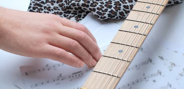 Closeup of a guitarist touching sheet music .isolated on a whit — Stock Photo, Image