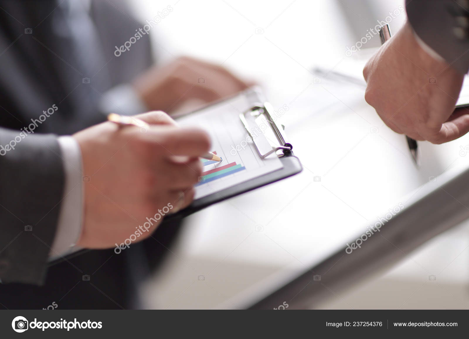 Businessman At Desk Checking A Financial Report And Pointing At