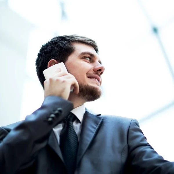 Modern ofiste cep telefonuyla konuşan genç bir iş adamı. — Stok fotoğraf