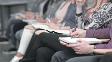 conferenc içinde oturan clipbord notlar alarak iş grubu