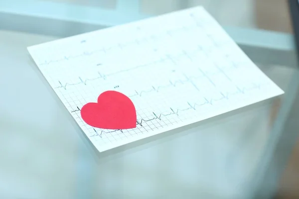 Stethoscoop, cardiogram en rood papier hart op tafel — Stockfoto