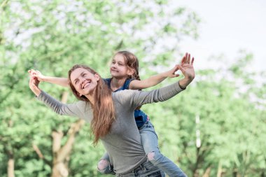 Sevimli genç kızı bir domuz sırtına binmek annesi ile