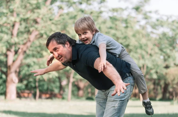Papa speelt met zijn zoontje op een wandeling in het Park . — Stockfoto