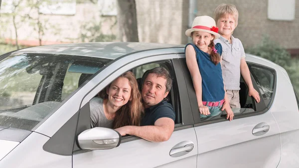 Família com duas crianças sentadas em seu carro familiar . — Fotografia de Stock