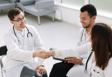 handshake of medical colleagues at the Desk in the hospital office