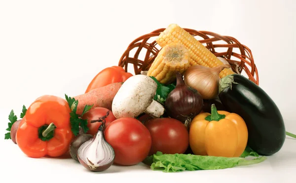 Cogumelos e uma variedade de legumes frescos em uma cesta de vime. — Fotografia de Stock