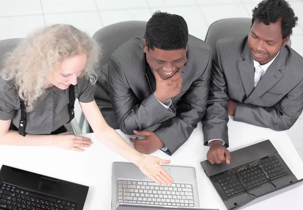 Alkalmazottak látszó-on laptop monitor, ül az asztalnál — Stock Fotó