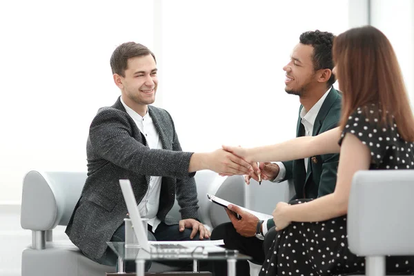 Jóvenes socios de negocios estrechando la mano antes de iniciar una reunión de negocios —  Fotos de Stock