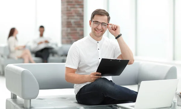 Uomo d'affari che lavora con i documenti, seduto nella hall del business center — Foto Stock