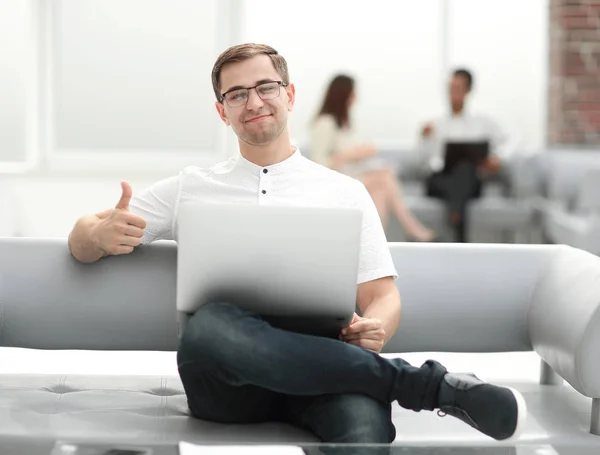Uomo sorridente con computer portatile mostrando pollice in su — Foto Stock