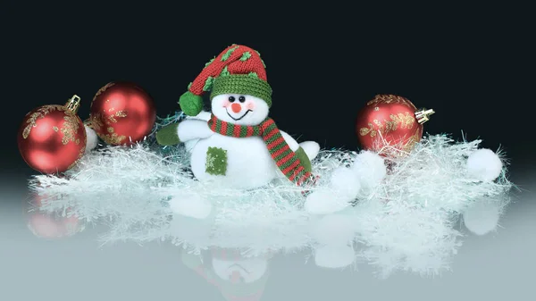 Boneco de neve de brinquedo com bolas vermelhas festivas. fundo preto — Fotografia de Stock