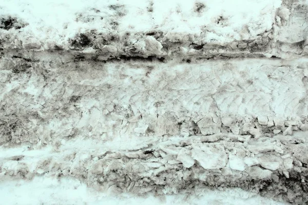 Следы различных автомобильных покрышек на грязном снегу. Тезисы, текстура — стоковое фото