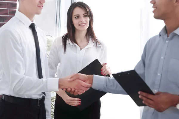 Handshake mladých obchodních partnerů v kanceláři — Stock fotografie