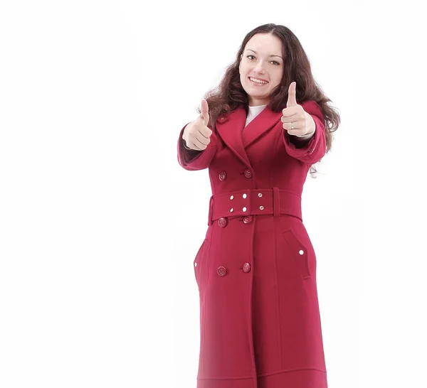 Όμορφη νεαρή γυναίκα με κόκκινο παλτό που δείχνει τους αντίχειρες επάνω. — Φωτογραφία Αρχείου